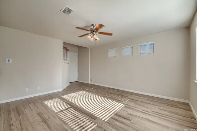 a view of a room with wooden floor and a ceiling fan