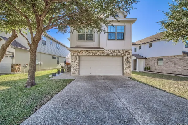 a view of a house with a yard and large tree