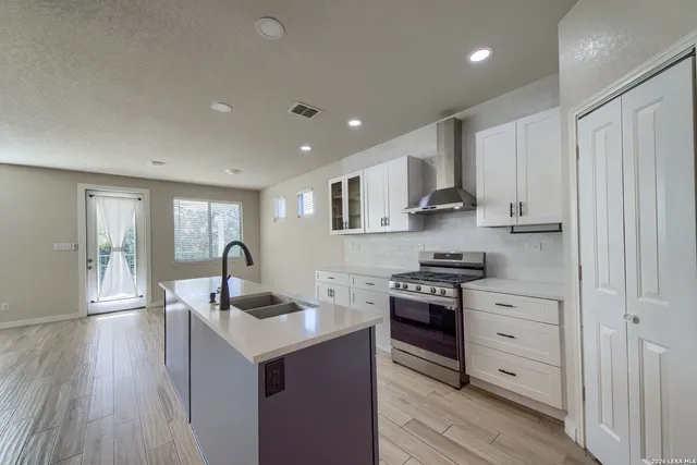 a kitchen with granite countertop kitchen island white cabinets and stainless steel appliances
