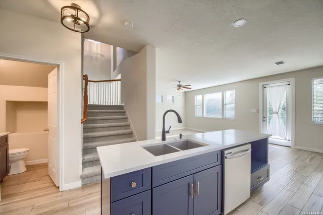 a kitchen with a sink cabinets and wooden floor