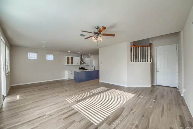 a view of a room with a ceiling fan hardwood floor and a ceiling fan
