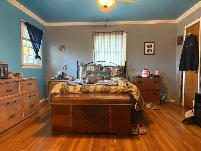 a bedroom with a bed and wooden floor