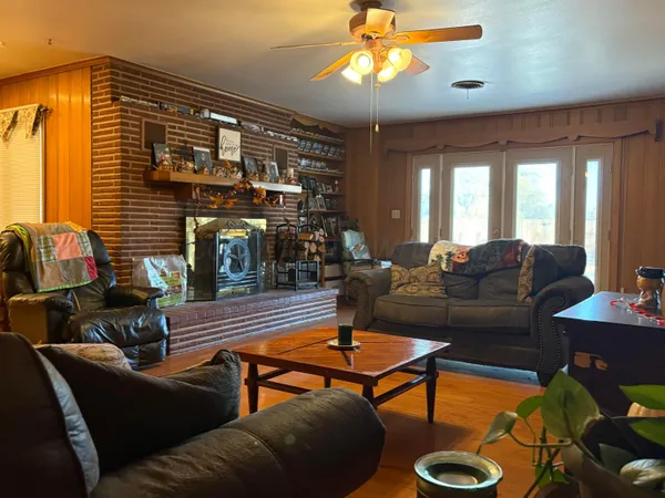 a living room with furniture a chandelier and a flat screen tv