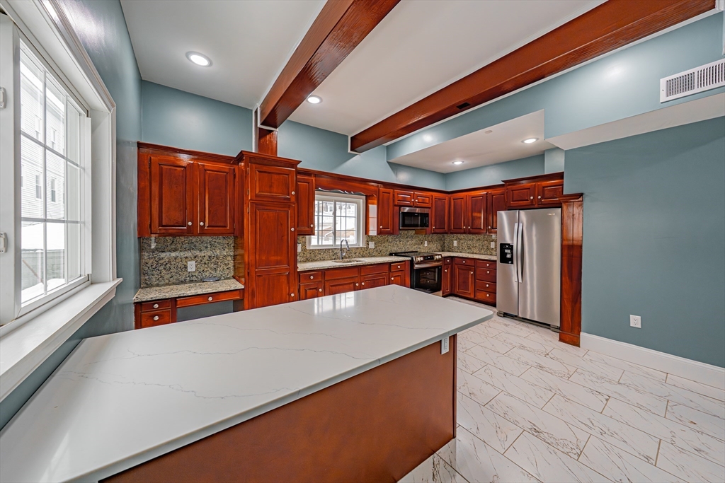 24 Tudor Street Chelsea, MA 02150 - Photo 12 of 36 a large kitchen with lots of counter space a sink and appliances