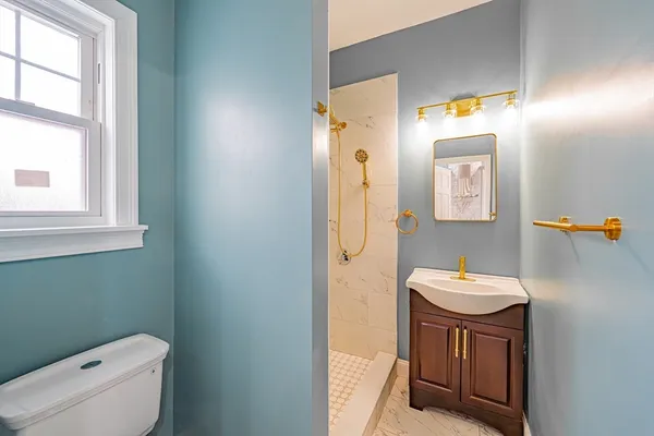 a bathroom with a toilet a sink and a mirror
