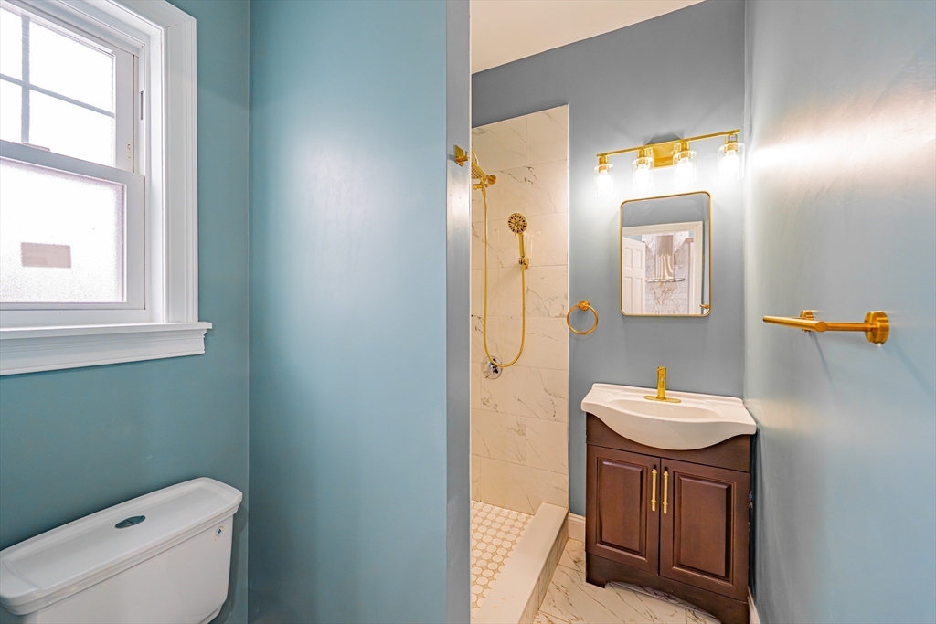 24 Tudor Street Chelsea, MA 02150 - Photo 26 of 36 a bathroom with a toilet a sink and a mirror