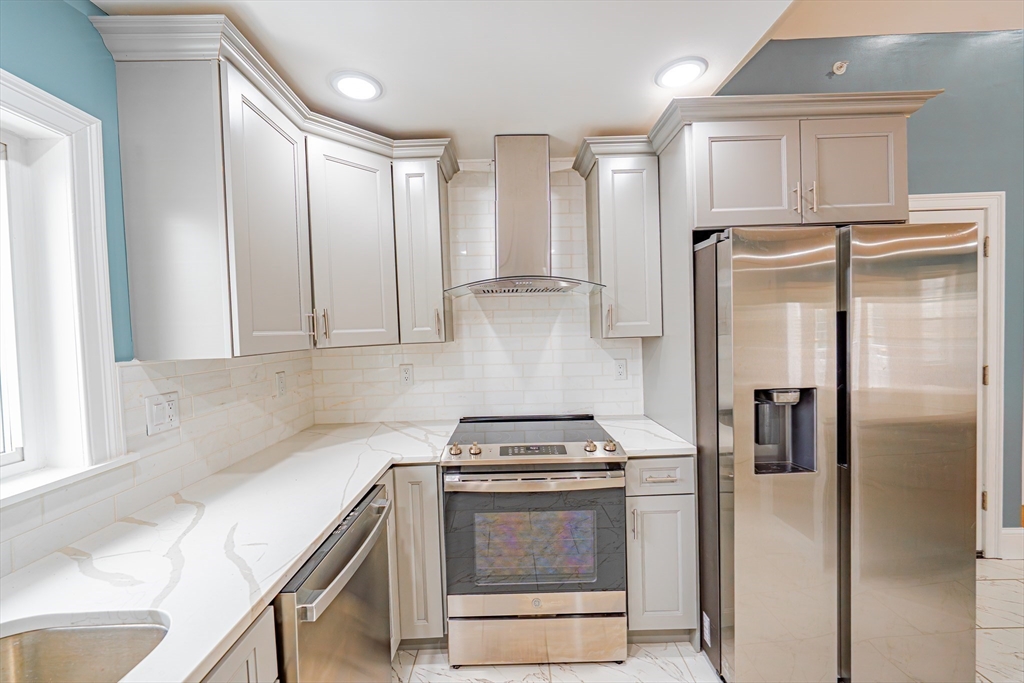 24 Tudor Street Chelsea, MA 02150 - Photo 32 of 36 a kitchen with stainless steel appliances granite countertop a refrigerator and a stove