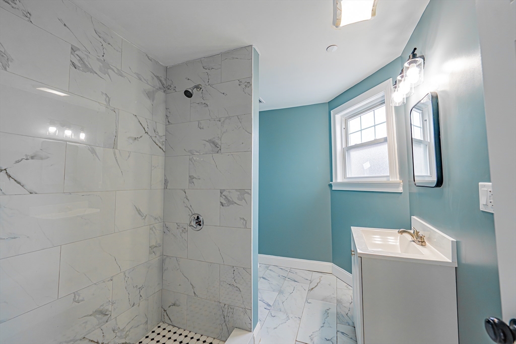 24 Tudor Street Chelsea, MA 02150 - Photo 35 of 36 a bathroom with a bathtub sink and shower