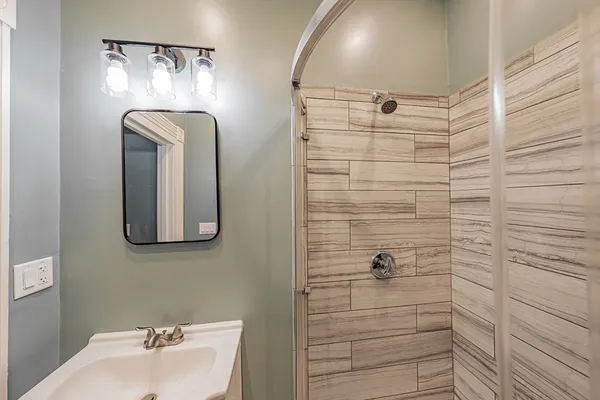 a bathroom with a mirror and shower