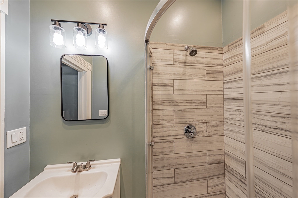 24 Tudor Street Chelsea, MA 02150 - Photo 7 of 36 a bathroom with a mirror and shower