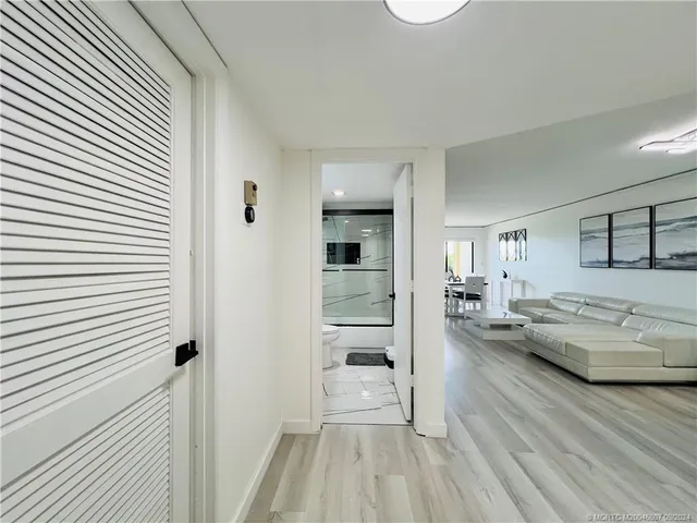 a living room with furniture a flat screen tv and floor to ceiling window