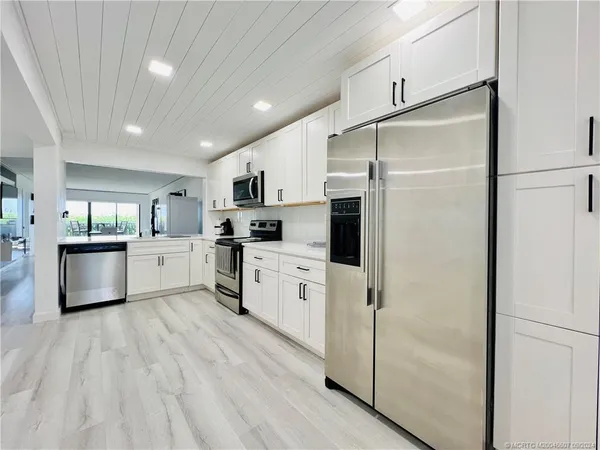 a kitchen with a table chairs and white cabinets