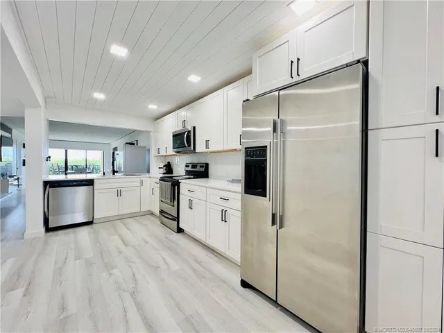 a kitchen with a table chairs and white cabinets