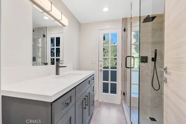 a bathroom with a sink a vanity a shower and a mirror