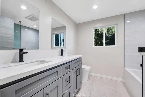 a bathroom with a double vanity sink toilet and shower