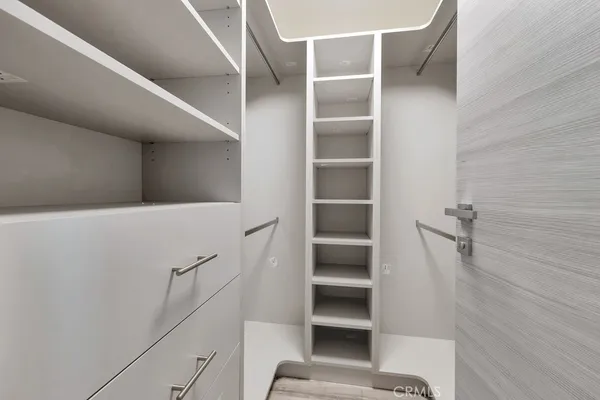 a view of walk in closet with empty racks