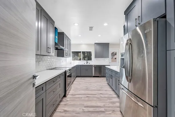 a large kitchen with stainless steel appliances lots of counter space and a sink