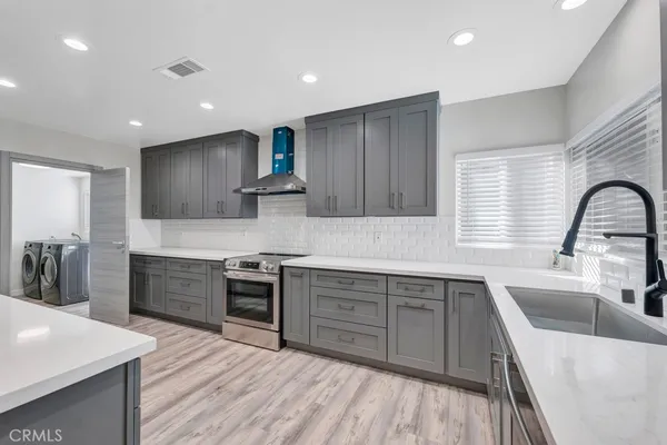 a kitchen with stainless steel appliances granite countertop wooden cabinets sink and stove