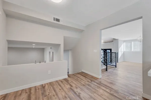 an empty room with wooden floor and a rug