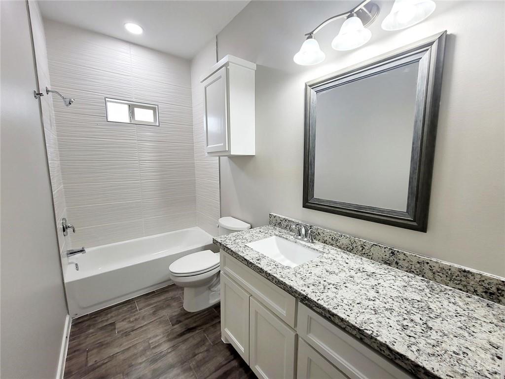 5805 Swallow Avenue, Unit 4 Mission, TX 78573 - Photo 17 of 19 a bathroom with a granite countertop sink toilet and shower