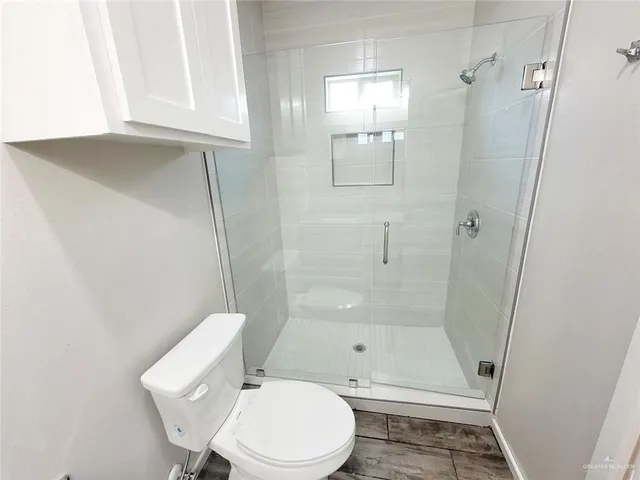a bathroom with a granite countertop toilet sink and mirror