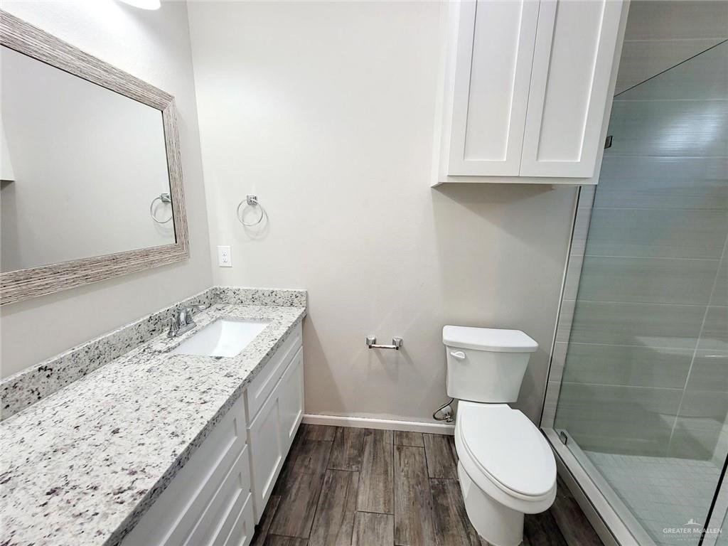 5805 Swallow Avenue, Unit 4 Mission, TX 78573 - Photo 19 of 19 a bathroom with a granite countertop toilet sink and mirror