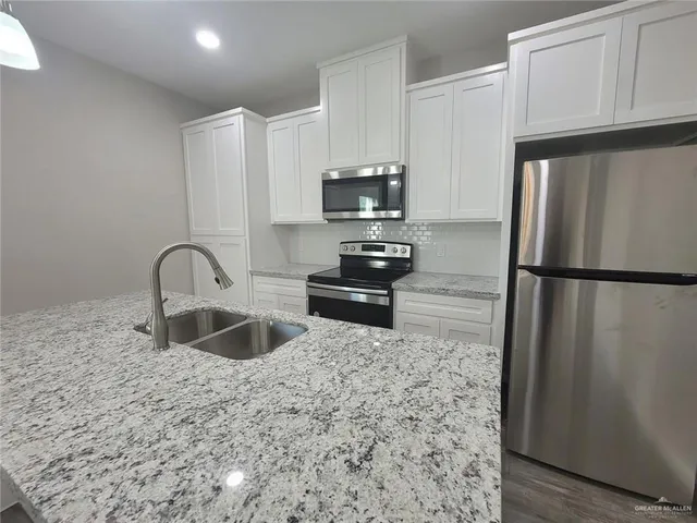 a kitchen with kitchen island sink refrigerator and microwave