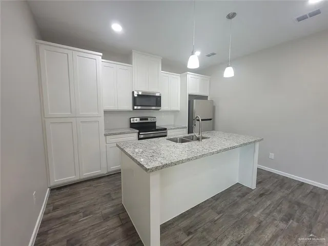 a large kitchen with a large counter top appliances and cabinets
