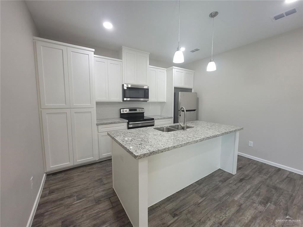 5805 Swallow Avenue, Unit 4 Mission, TX 78573 - Photo 10 of 19 a kitchen with kitchen island sink refrigerator and microwave