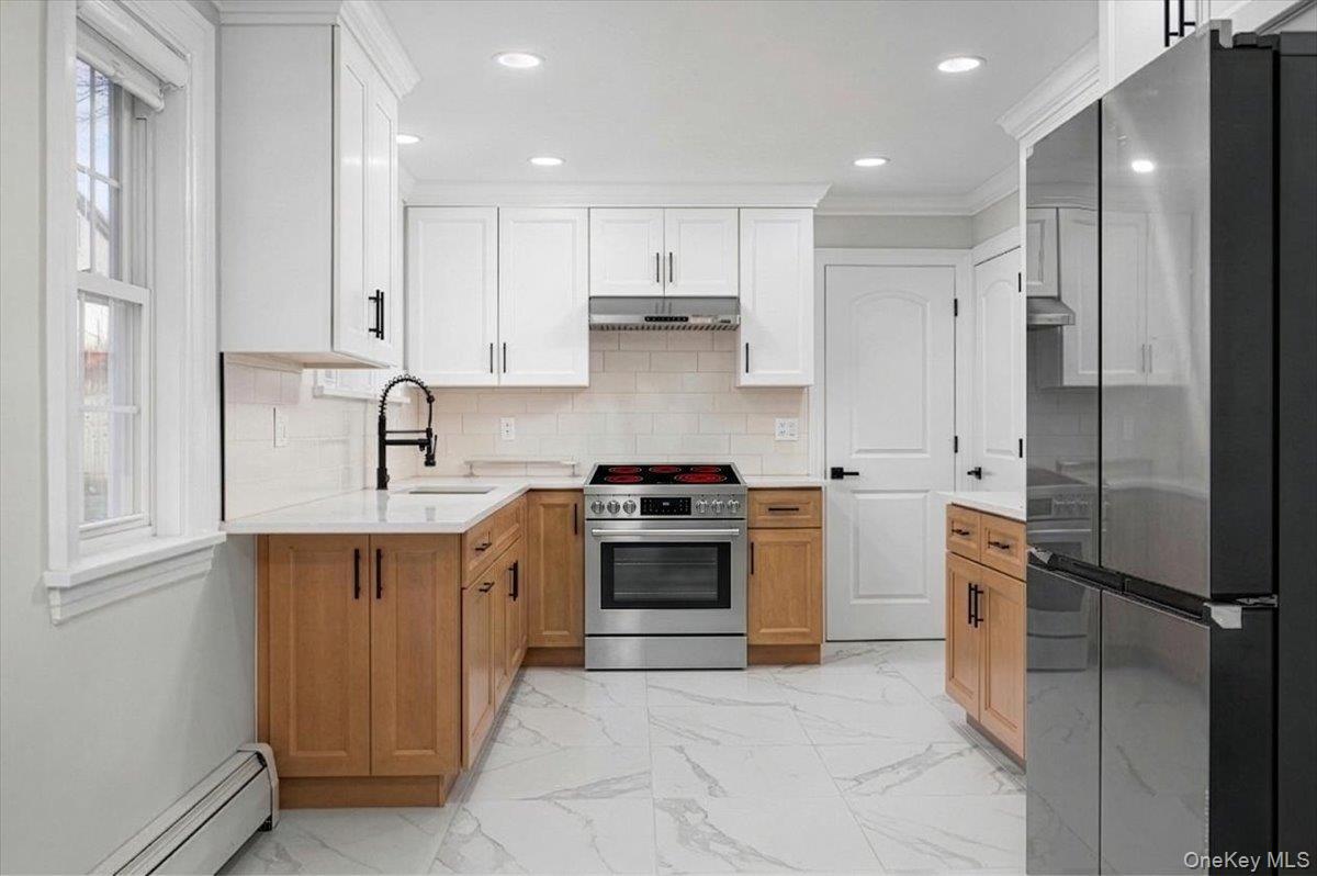 28 Cross Street Bronxville, NY 10708 - Photo 12 of 34 a kitchen with stainless steel appliances granite countertop a sink stove and refrigerator