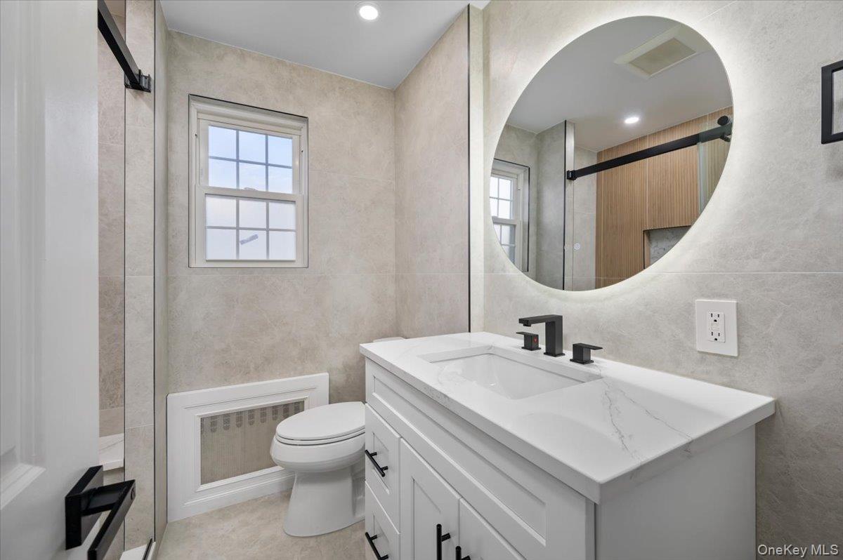 28 Cross Street Bronxville, NY 10708 - Photo 18 of 34 a bathroom with a toilet sink and mirror