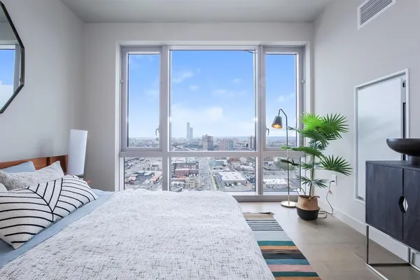 a bedroom with a large bed and a potted plant