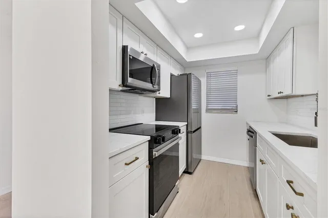 a kitchen with stainless steel appliances granite countertop a sink and a stove top oven