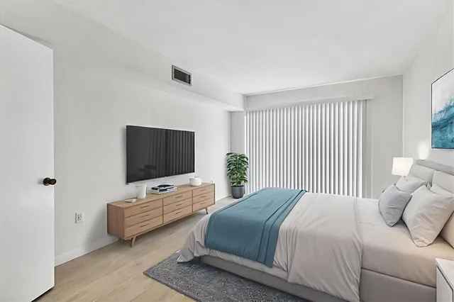a bedroom with a bed and flat screen tv