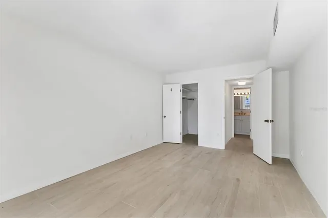 an empty room with closet and mirror