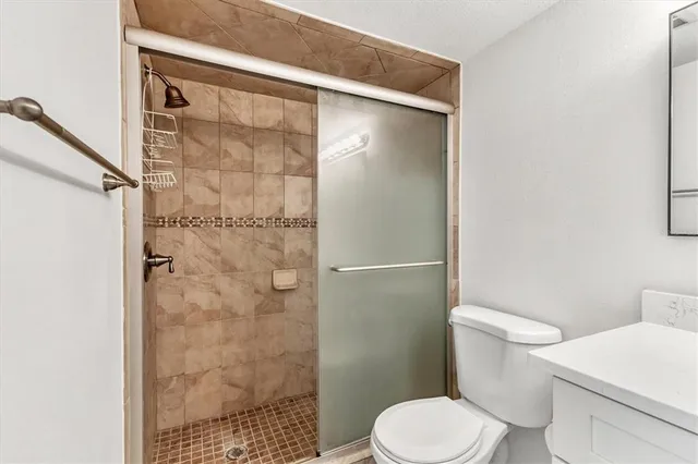 a white toilet sitting next to a shower