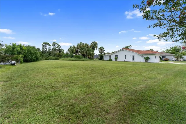 a view of a big yard with a house in the background