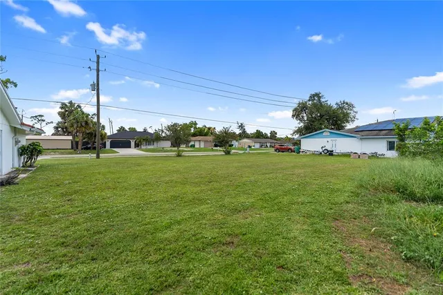 a view of a house with a big yard and potted plants