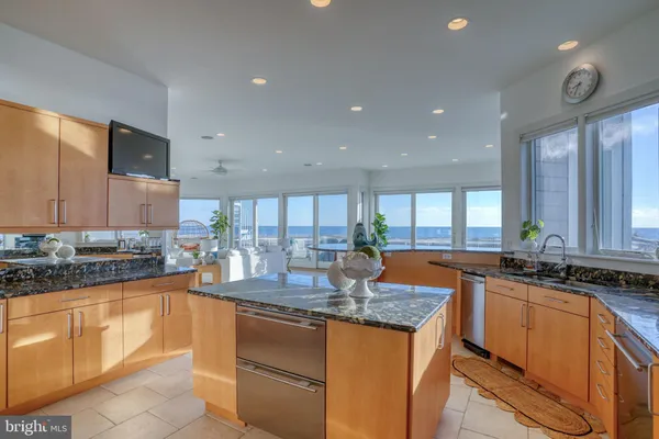 a kitchen with stainless steel appliances kitchen island granite countertop a sink and a refrigerator