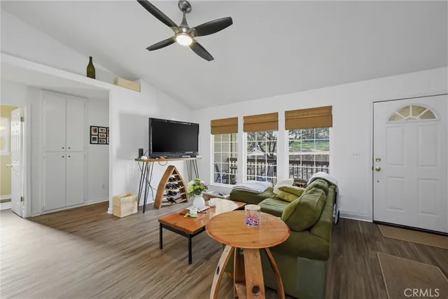 a living room with furniture a flat screen tv and a window