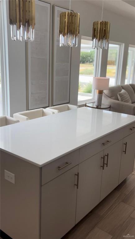 5323 Vision Street Rio Grande City, TX 78582 - Photo 14 of 16 Kitchen featuring pendant lighting, light wood-style flooring, a center island, and white cabinetry