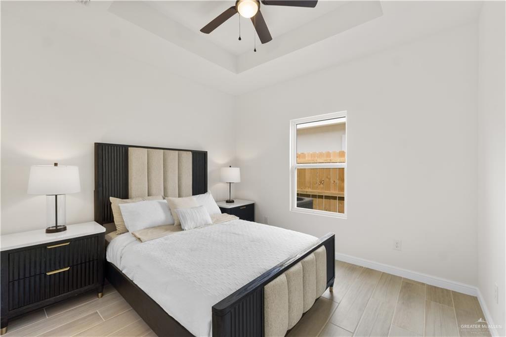 5323 Vision Street Rio Grande City, TX 78582 - Photo 16 of 16 Bedroom with light wood-style flooring, a raised ceiling, and a ceiling fan