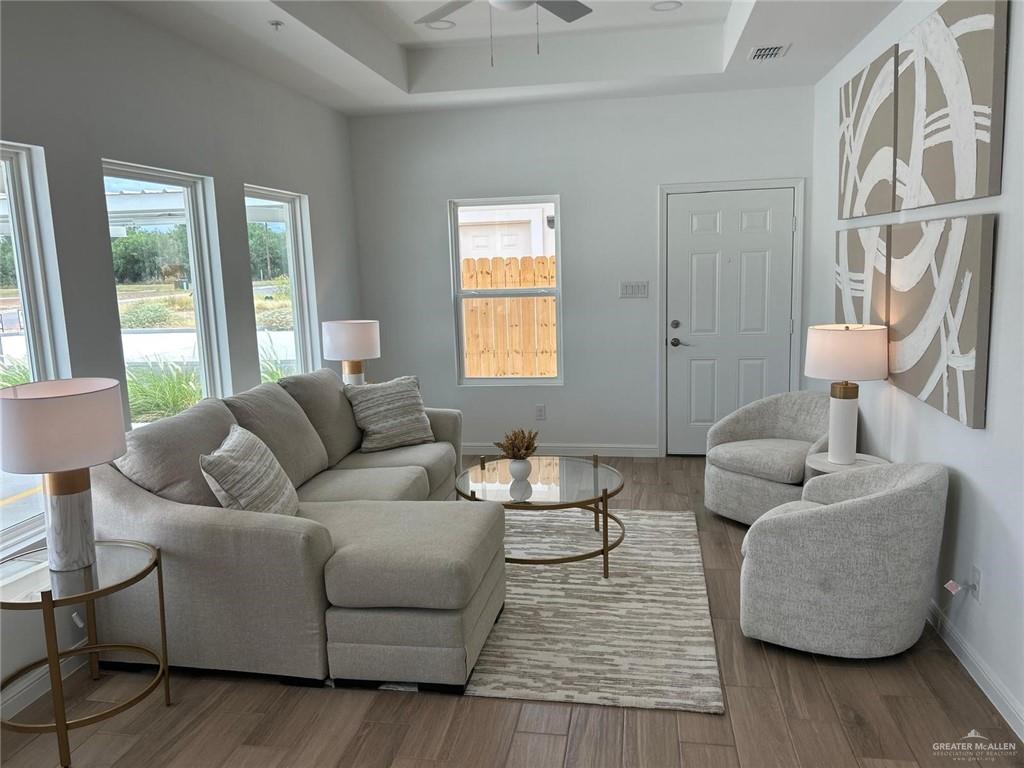 5323 Vision Street Rio Grande City, TX 78582 - Photo 10 of 16 Living room featuring wood finished floors, a tray ceiling, and a ceiling fan
