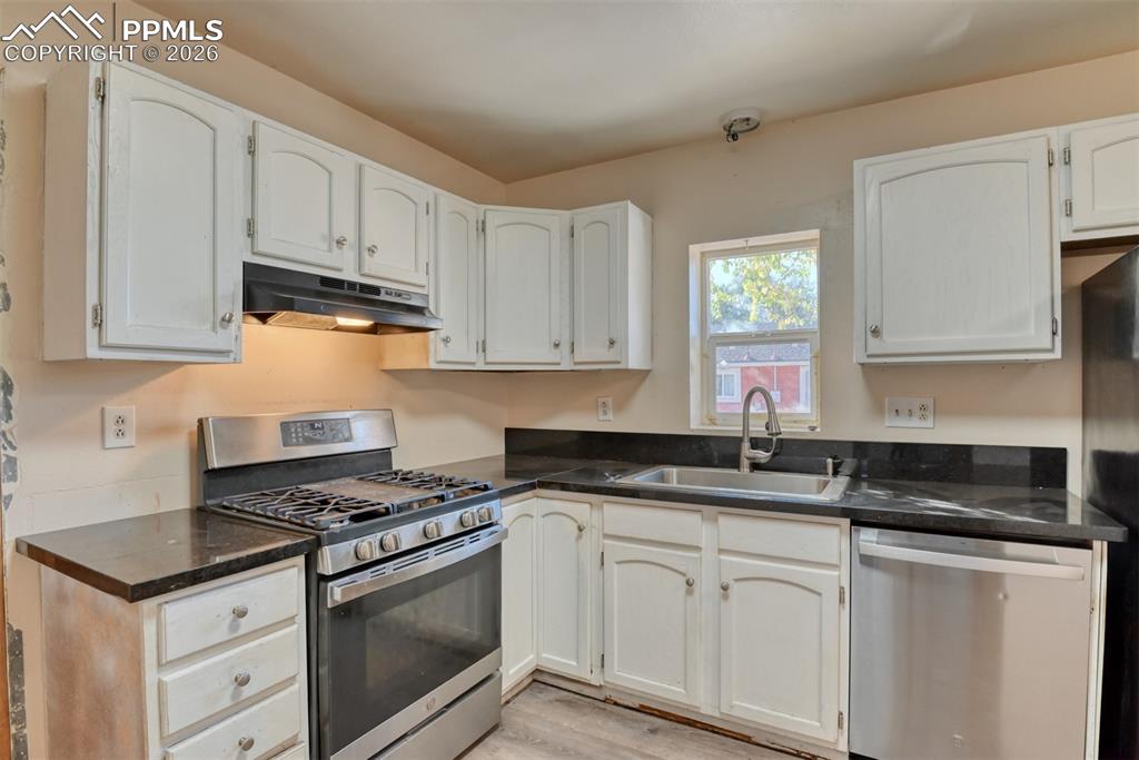 632 Santa Fe Street Colorado Springs, CO 80903 - Photo 12 of 24 a kitchen with granite countertop white cabinets and white appliances