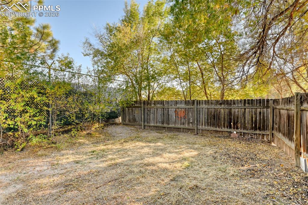632 Santa Fe Street Colorado Springs, CO 80903 - Photo 4 of 24 a view of backyard with wooden fence and trees