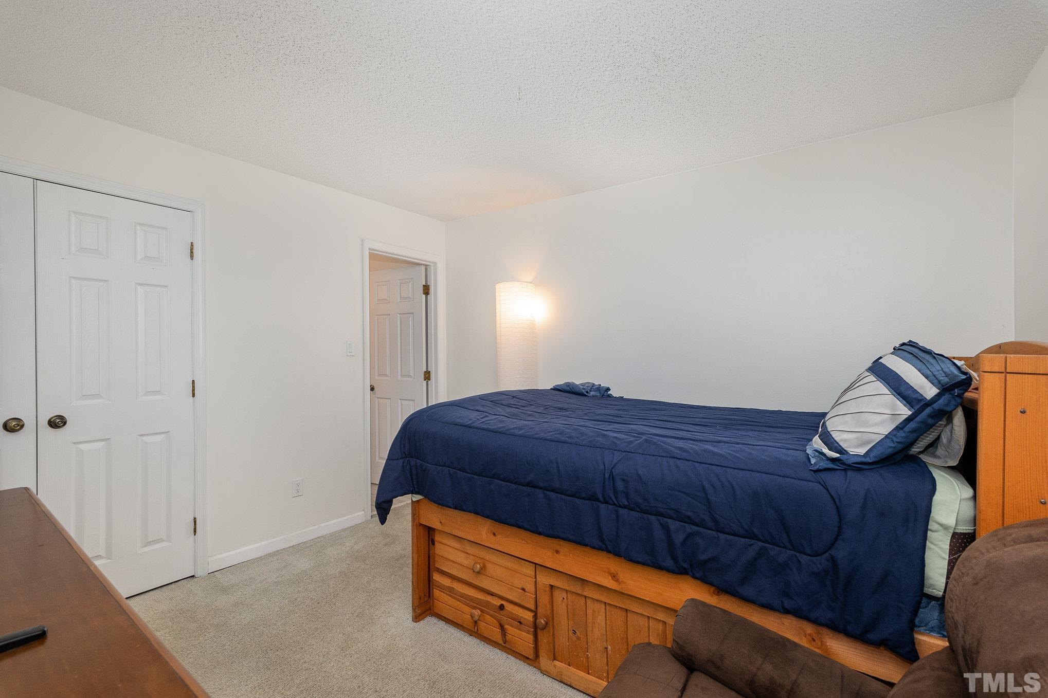 3219 Mill Run, Unit 175 Raleigh, NC 27612 - Photo 11 of 16 a room with a bed and a mirror