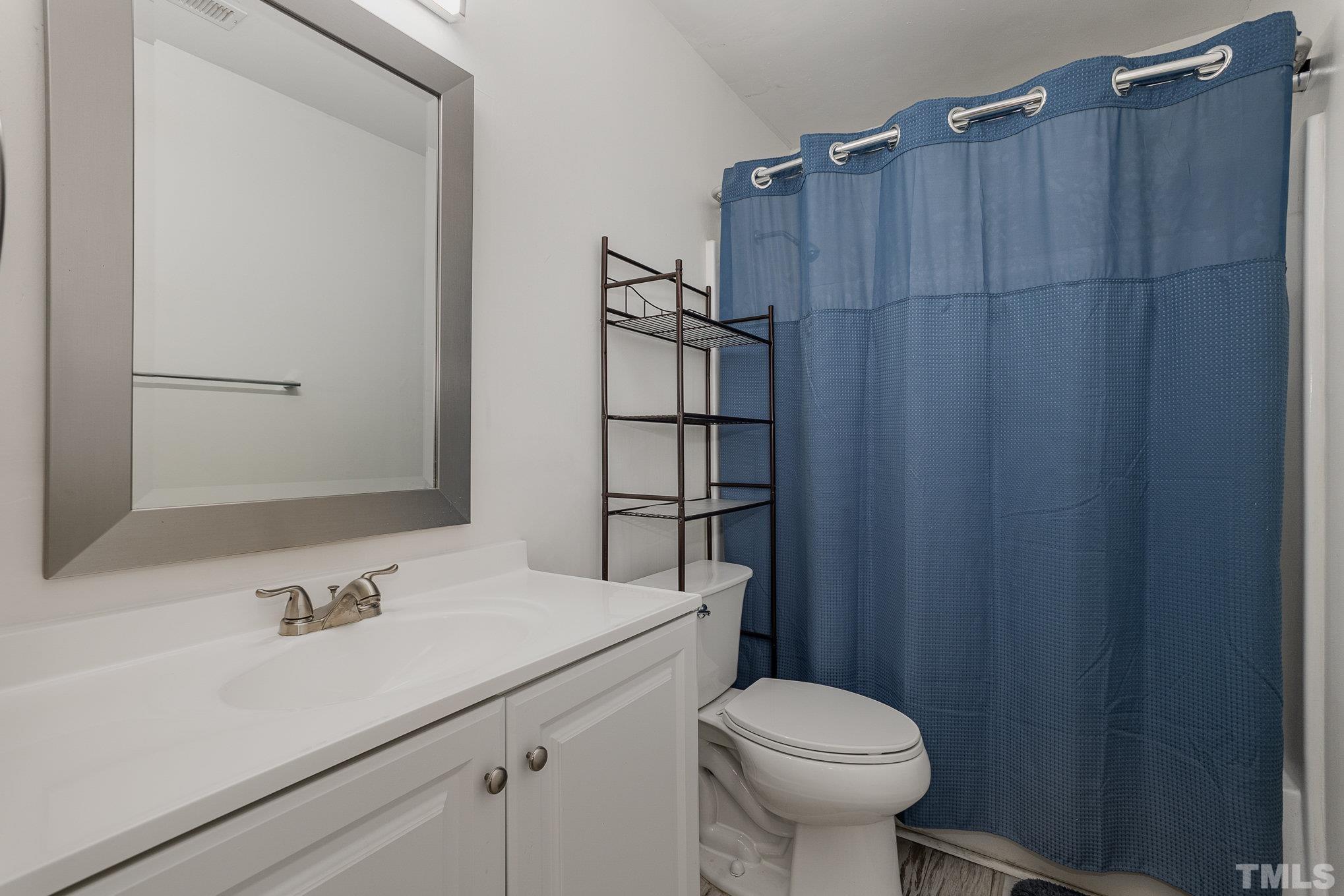 3219 Mill Run, Unit 175 Raleigh, NC 27612 - Photo 13 of 16 a bathroom with a sink a toilet and shower