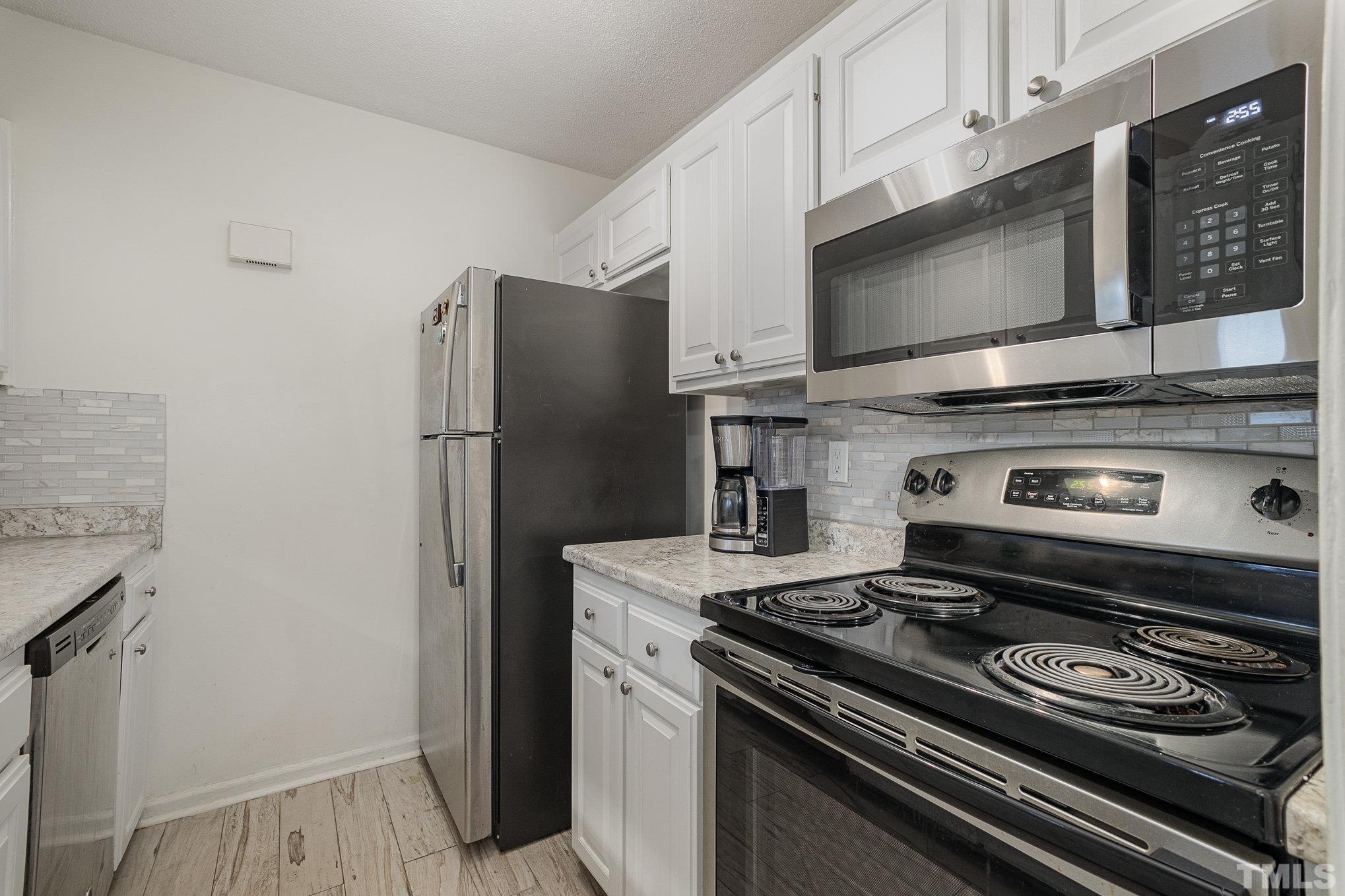 3219 Mill Run, Unit 175 Raleigh, NC 27612 - Photo 6 of 16 a kitchen with a stove and a microwave