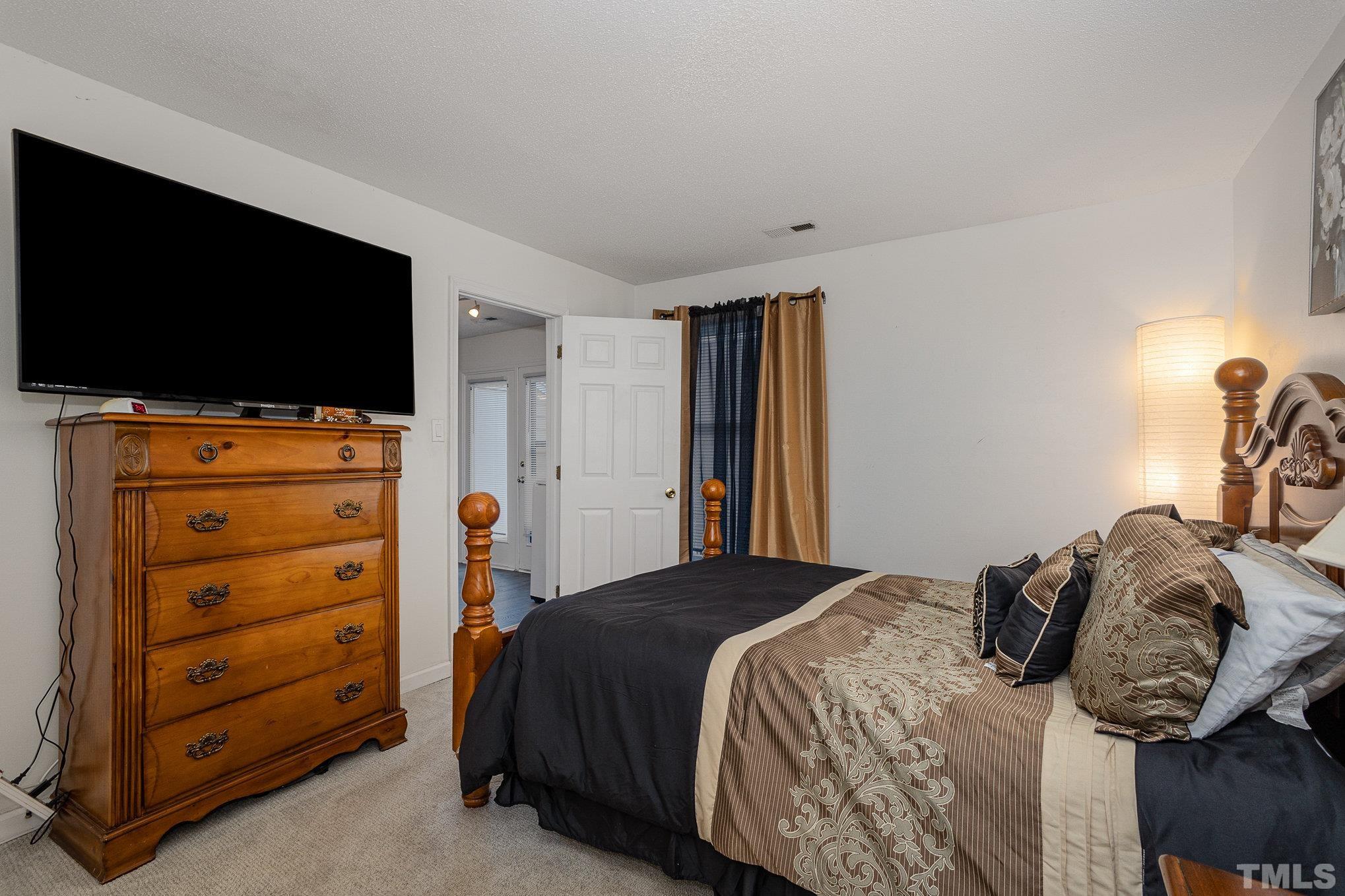 3219 Mill Run, Unit 175 Raleigh, NC 27612 - Photo 10 of 16 a bedroom with a bed and a flat screen tv