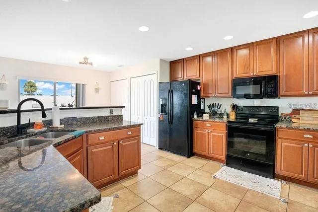 a kitchen with stainless steel appliances granite countertop a refrigerator and a sink